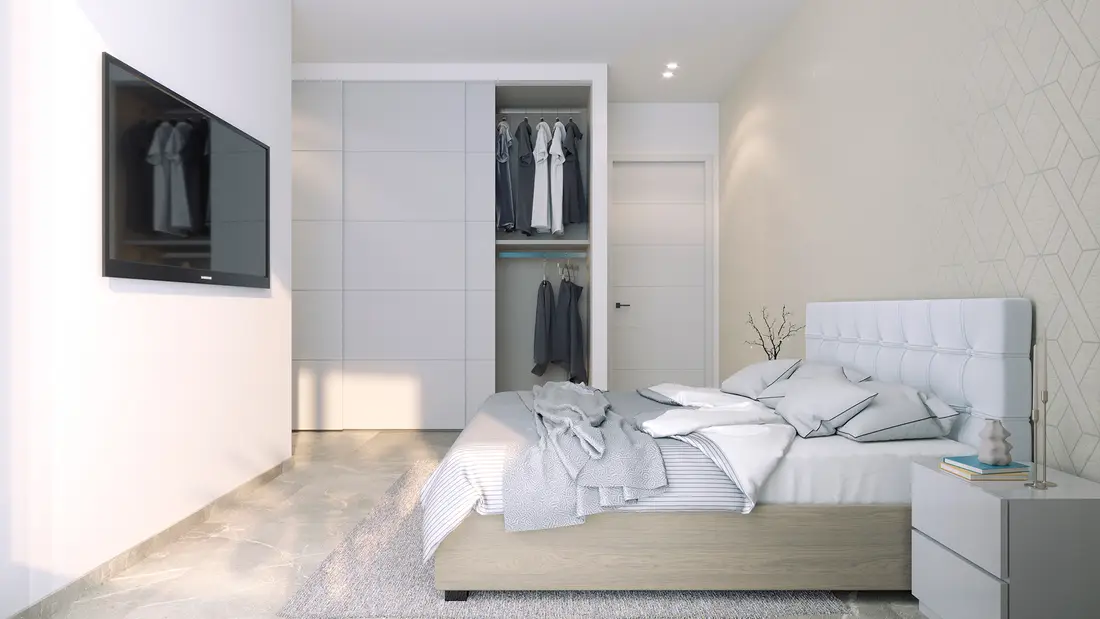 Main bedroom of a two-bedroom apartment at Rodas Playa with fitted wardrobes and a wallpaper feature wall