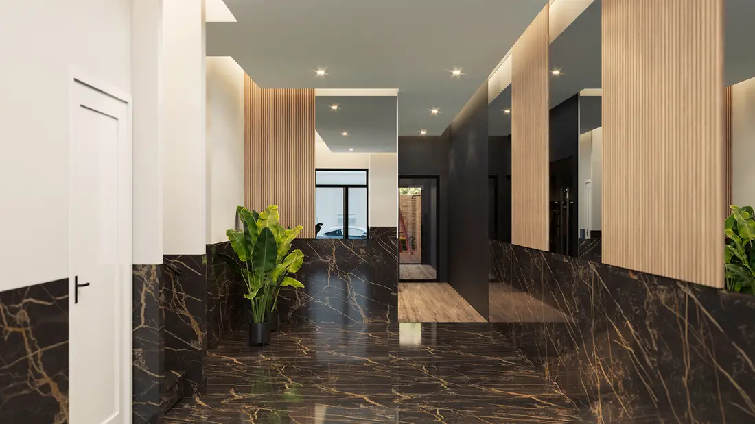 The entrance lobby at Rodas Playa, with marble floor and timber-slat walls, looking through to the street
